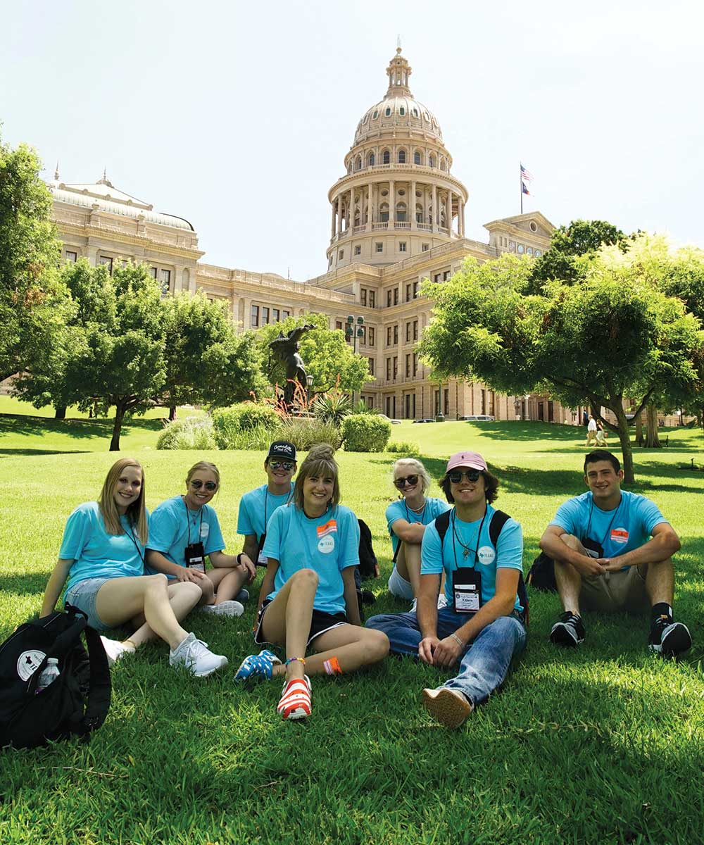 During their first full day in Austin, students take a break in the shade on the Capitol lawn in 2019.