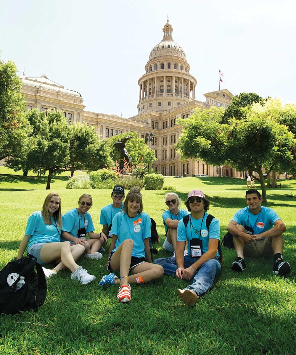 During their first full day in Austin, students take  a break in the shade on the Capitol lawn in 2019.